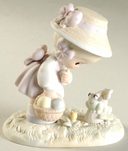 This Precious Moments figurine depicts a Girl With Easter Basket and Frog.
