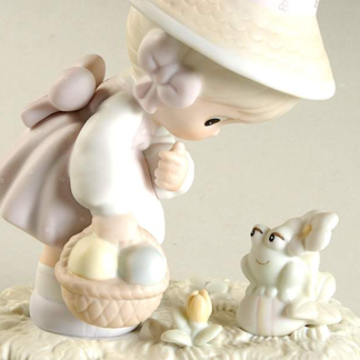 Precious Moments figurine depicts a Girl With Easter Basket and Frog.