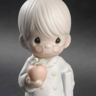 porcelain figurine depicts a Boy In Glasses With Book and Apple.