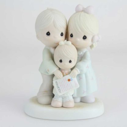 Porcelain figurine of father, mother and daughter with adoption certificate.
