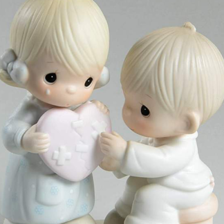 Precious Moments figurine depicts a girl and boy with a bandaged heart.
