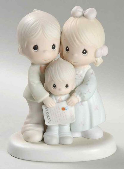 porcelain figurine of father, mother, boy and adoption certificate