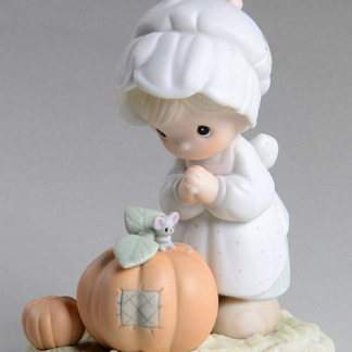 This porcelain figurine features a girl with pumpkins