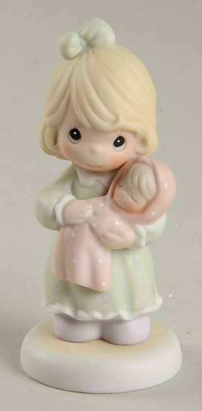 This porcelain figurine depicts a girl holding a newborn baby.
