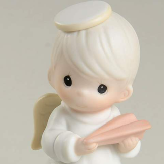 porcelain figurine depicts a boy angel with a paper airplane.