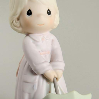 porcelain figurine featuring child with green umbrella