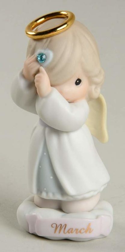 This porcelain figurine depicts an angel with a gold halo and birthstone (aquamarine rhinestone).