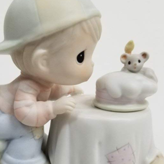 Precious Moments figurine depicts a boy blowing out a candle on a cake - held by mouse.