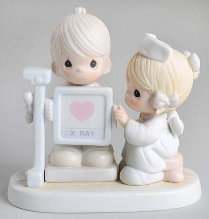 Precious Moments figurine depicts a nurse x-raying a patient.