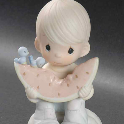 Precious Moments figurine depicts a A Boy And Bluebirds Eating A Slice Of Watermelon.