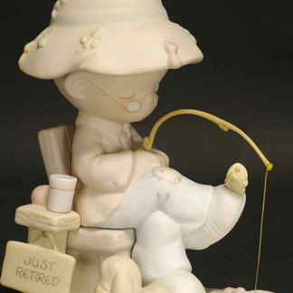 Precious Moments figurine depicts a retired man fishing and napping, with a dog at his feet. 