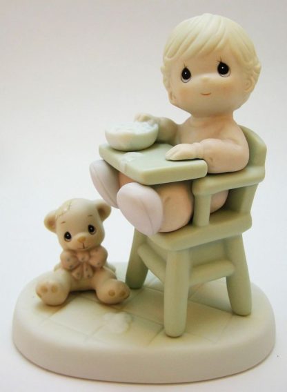 Porcelain figurine of A Baby In A Highchair With A Bowl And A Teddy Bear At Her Feet.