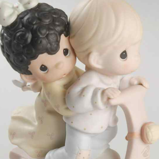 Porcelain figurine featuring a boy and girl riding together on a scooter.