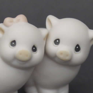 Porcelain figurine depicting boy and girl pigs
