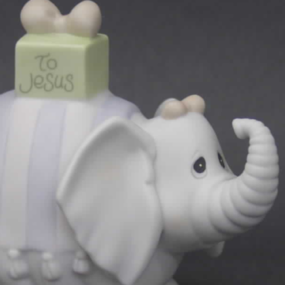 porcelain figurine features an elephant with a gift on its back.