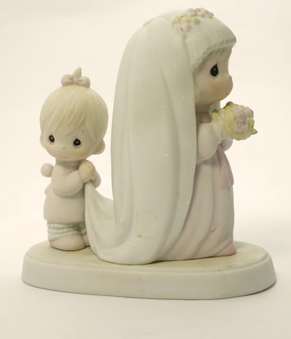 porcelain figurine of blushing bride with flower girl holding bridal train