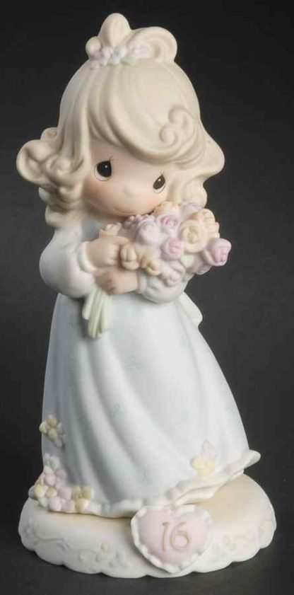 Porcelain figurine from the Growing In Grace series, this piece depicts a girl holding a bouquet of sixteen roses.