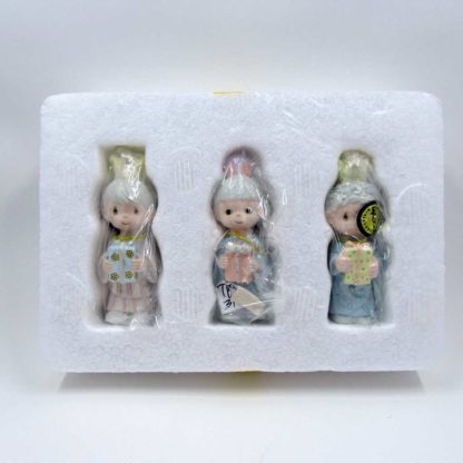 three figurines in original plastic and styrofoam packaging
